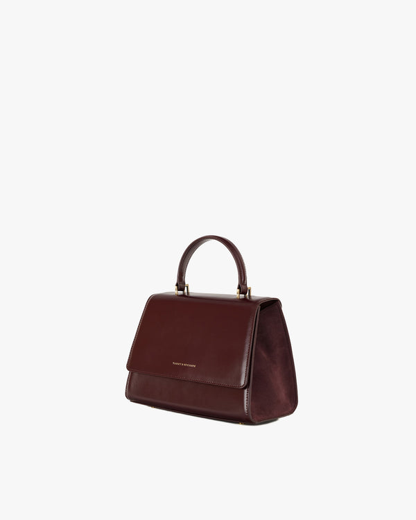 ALEXIA bag in Mahogany, three-quarter view, standing, short handle shown, suede side panel visible