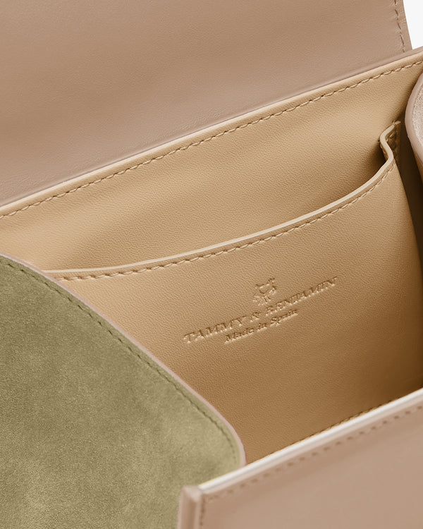 ALEXIA NANO bag in Beige, open interior view with slip pocket, green suede flap, embossed logo