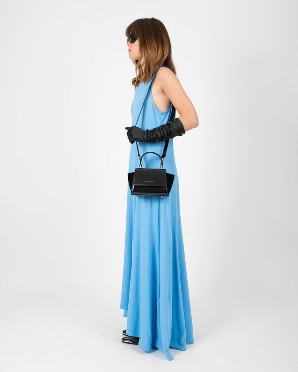 ALEXIA NANO bag in black worn crossbody, side view on model in blue dress