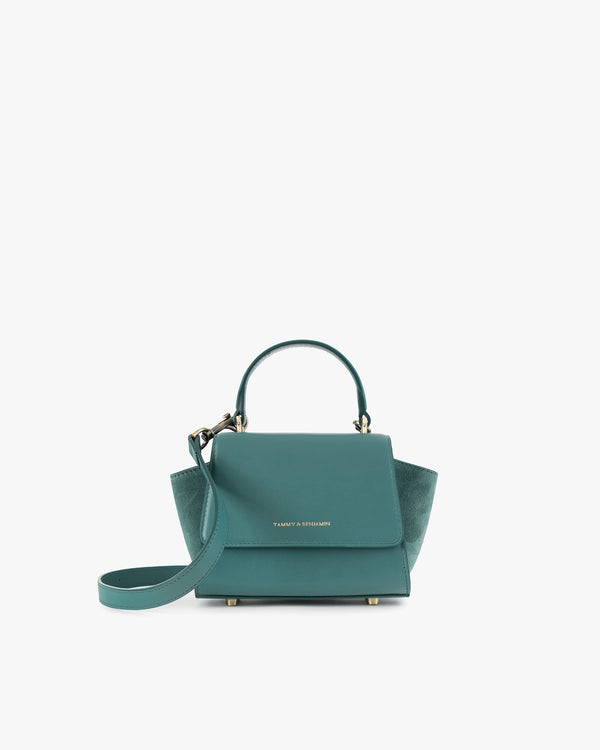 ALEXIA NANO bag in turquoise, front view, placed down, with short handle and detachable strap