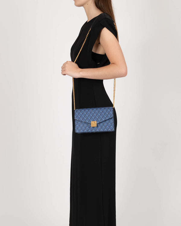 Sac ELEANOR Bleu porté à l'épaule avec chaîne, vue de profil sur un modèle en robe noire