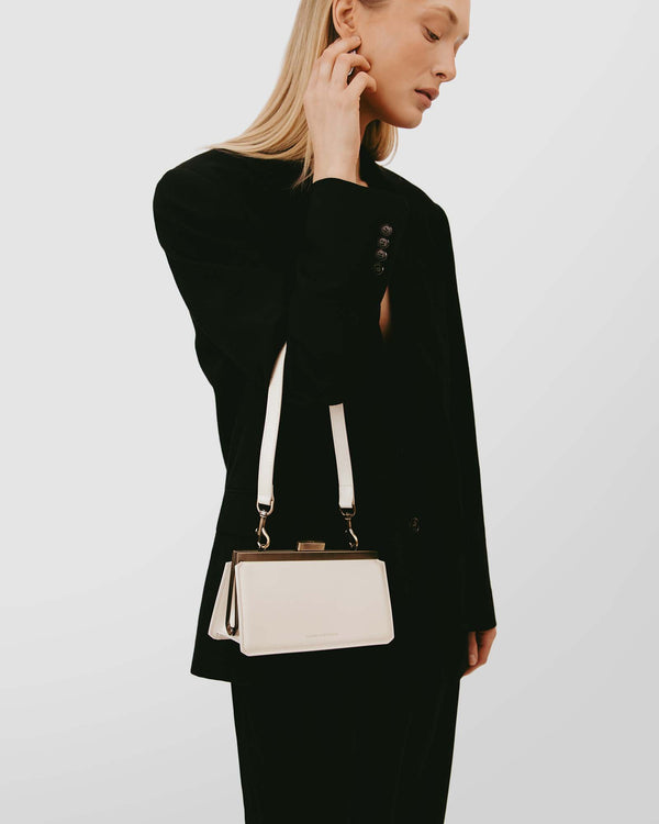 JEANNE BAGUETTE bag in Ivory worn on the shoulder with double strap, retro clasp, side view