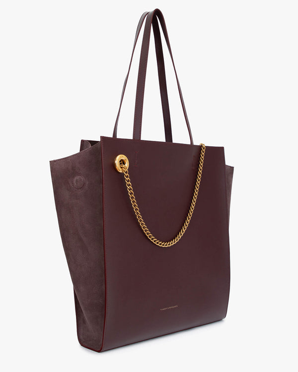 Sac LEXI GM Aubergine de trois quarts, anses en cuir, chaîne amovible dorée, panneaux en suède