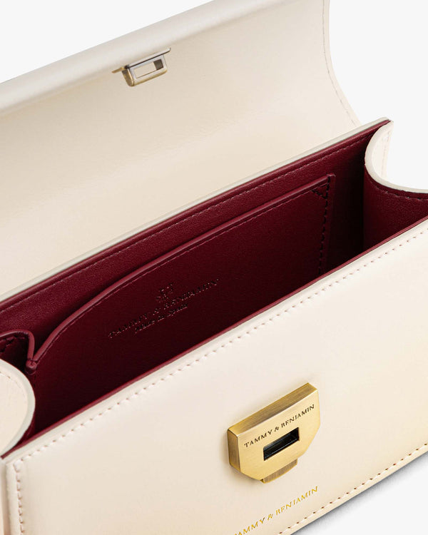 THEA MINI bag in Ivory, open view showing burgundy card pocket and engraved gold clasp