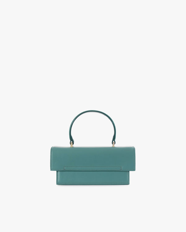 THEA MINI bag in turquoise, front view, flap closed, standing, with short top handle