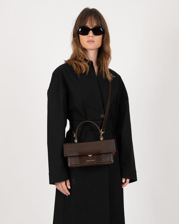 THEA bag in brown embossed lizard, worn crossbody with top handle, oversize flap closed