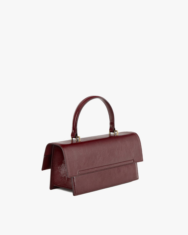 THEA bag in burgundy naplak leather, three-quarter back view, structured handle and oversized flap