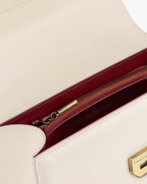 THEA bag in Ivory, interior view showing zip pocket with burgundy lining and gold clasp