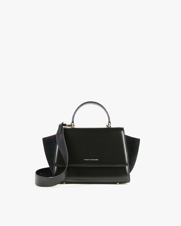 ALEXIA bag in black, front view standing, top handle with detachable strap attached, side wings visible