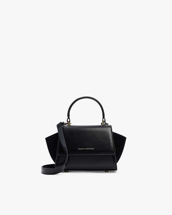 ALEXIA NANO bag in black, front view, flap closed, rigid handle up, removable strap attached
