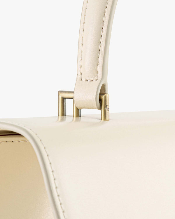THEA bag in Ivory, close-up of the metal hardware attaching the top handle to the flap