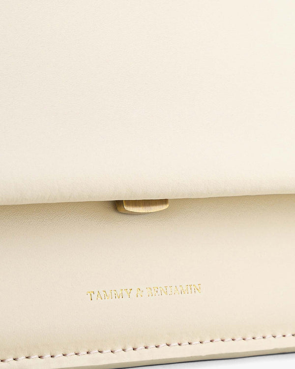 THEA MINI bag in Ivory, close-up on gold clasp and flap, Tammy & Benjamin embossed logo